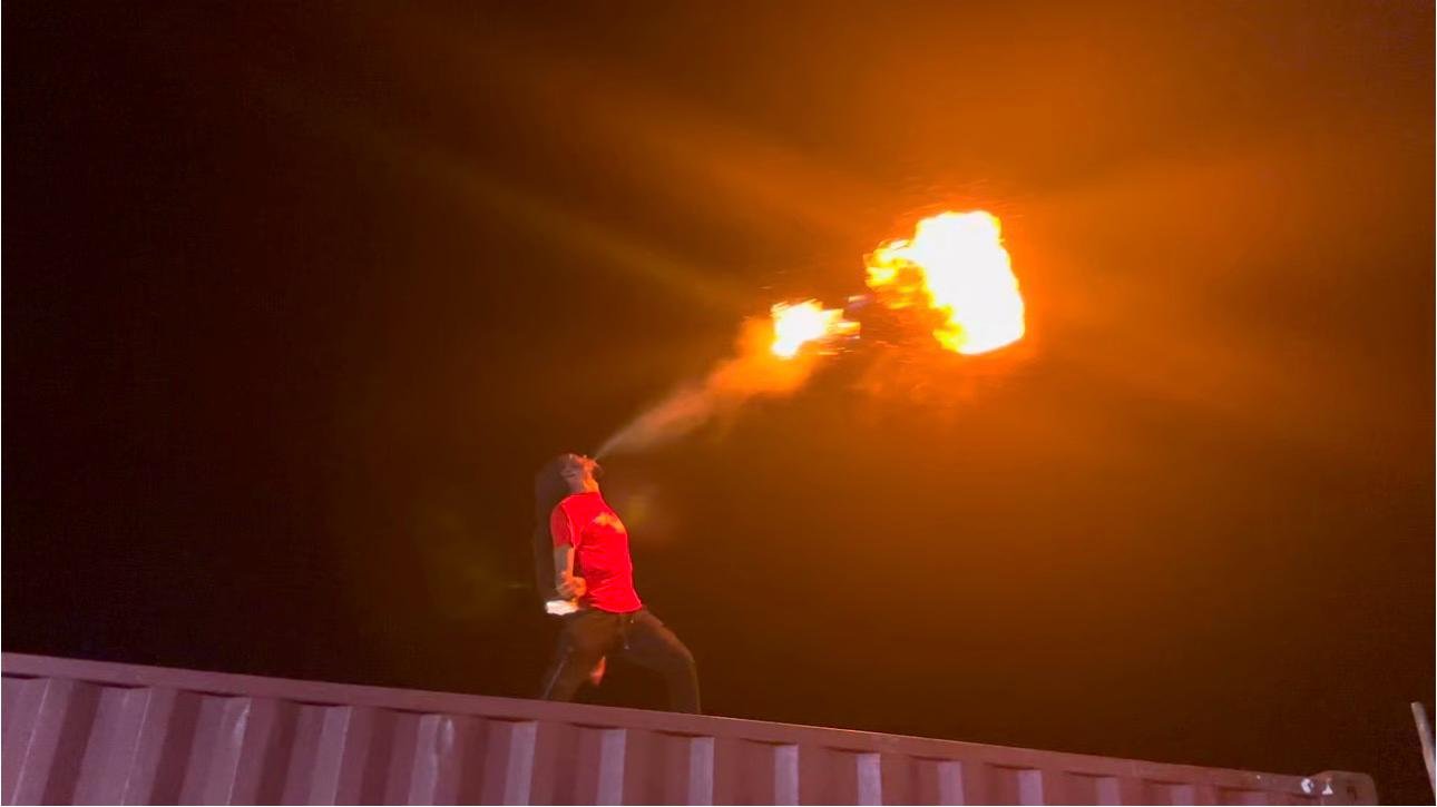 A fire eater blowing fire into the air at Vincy Mas 2024